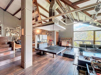 Experience luxury living in this stunning property, featuring a unique architectural design with exposed wooden beams and high ceilings.