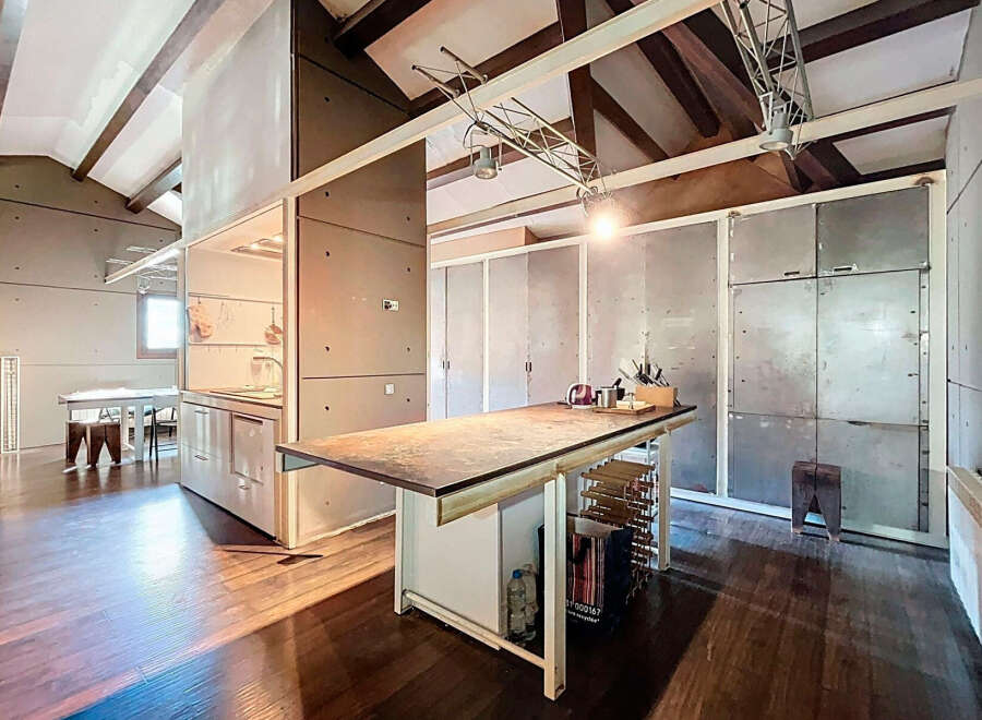 This stunning property boasts a modern, open-concept kitchen with sleek concrete accents and a spacious island.