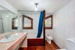 This charming bathroom features a unique design with wooden-framed windows, adding a touch of rustic elegance.