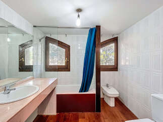 This charming bathroom features a unique design with wooden-framed windows, adding a touch of rustic elegance.