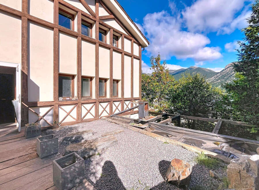 This stunning property boasts a unique architectural design with exposed wooden beams and a charming facade.