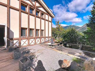 This stunning property boasts a unique architectural design with exposed wooden beams and a charming facade.