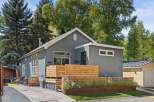 This stunning property boasts a modern design with a beautiful wooden fence and lush landscaping, creating a welcoming curb appeal.