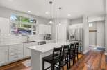 This stunning kitchen boasts a modern design with sleek white cabinetry and a spacious island, perfect for both cooking and entertaining.