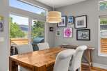 This stunning dining area boasts a rustic wooden table and elegant white chairs, perfect for hosting gatherings.
