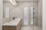 Step into luxury with this stunning bathroom featuring a sleek double vanity and a spacious glass-enclosed shower.