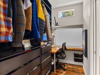 Step into this stylish home office, complete with a built-in desk and ample storage.
