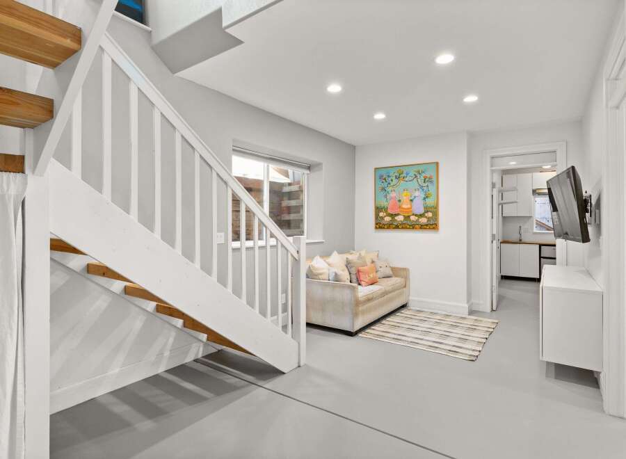 Step into this inviting space featuring a stylish staircase and a cozy living area.