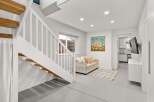 Step into this inviting space featuring a stylish staircase and a cozy living area.