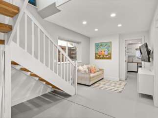 Step into this inviting space featuring a stylish staircase and a cozy living area.