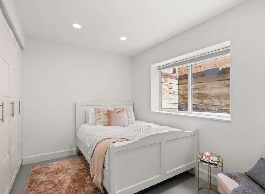 This charming bedroom features a cozy bed with plush pillows and a soft rug, creating a warm and inviting atmosphere.