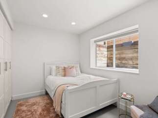 This charming bedroom features a cozy bed with plush pillows and a soft rug, creating a warm and inviting atmosphere.