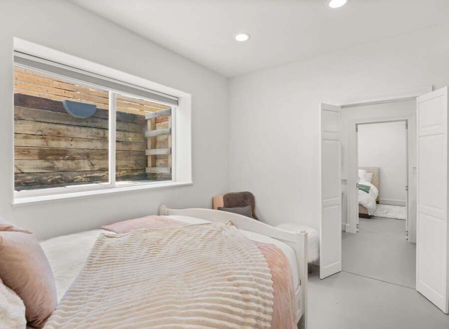 This cozy bedroom features a comfortable bed with soft bedding and a plush throw, perfect for relaxation.