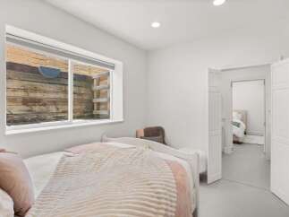 This cozy bedroom features a comfortable bed with soft bedding and a plush throw, perfect for relaxation.