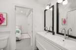 Step into a bright and modern bathroom, featuring a sleek double vanity and stylish black-framed mirrors.