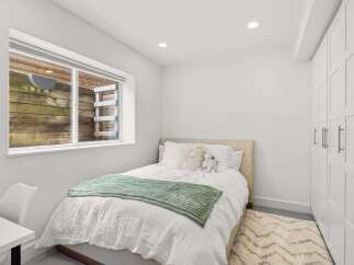 This cozy bedroom offers a serene retreat with its neutral color palette and inviting ambiance.
