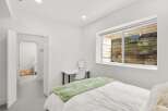 This bright and airy bedroom offers a serene retreat with its minimalist design and ample natural light.