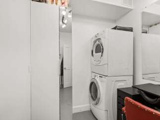 This property features a convenient laundry area with a stacked washer and dryer, perfect for modern living.