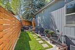 Enjoy outdoor living in this charming backyard oasis! This property features a beautifully landscaped yard with a lush green lawn and a stone pathway.