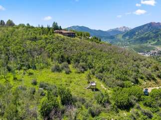 Nestled on a lush hillside, this stunning property offers breathtaking views of the surrounding mountains and valley.
