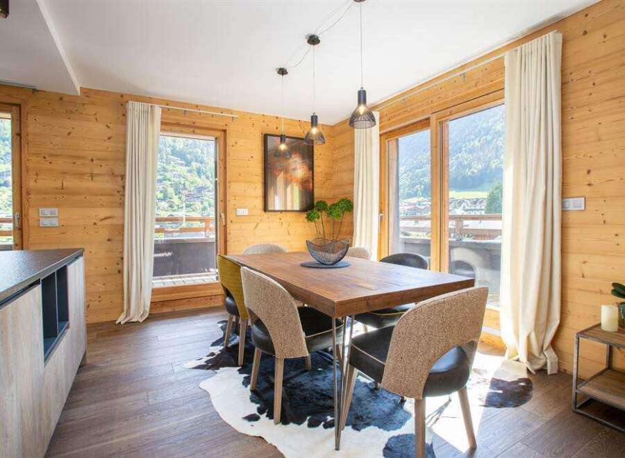 Experience the charm of this stunning property, featuring a beautifully designed dining area with a rustic wooden table and stylish chairs.