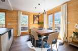 Experience the charm of this stunning property, featuring a beautifully designed dining area with a rustic wooden table and stylish chairs.