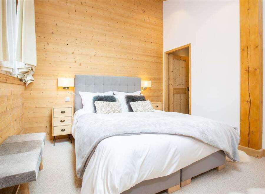 This cozy bedroom features a stunning wooden accent wall, creating a warm and inviting atmosphere.