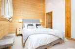 This cozy bedroom features a stunning wooden accent wall, creating a warm and inviting atmosphere.