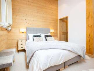 This cozy bedroom features a stunning wooden accent wall, creating a warm and inviting atmosphere.