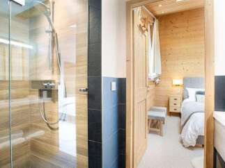 Step into luxury with this stunning property featuring a modern shower and a cozy bedroom.