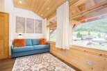 Experience the charm of this cozy living space, featuring a comfortable blue sofa adorned with vibrant orange pillows.
