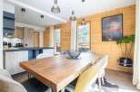 Experience the charm of this stunning property, featuring a beautifully designed dining area with a rustic wooden table and stylish chairs.