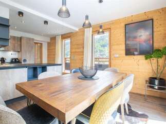 Experience the charm of this stunning property, featuring a beautifully designed dining area with a rustic wooden table and stylish chairs.