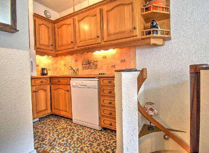 Discover the charm of this cozy kitchen, featuring classic wooden cabinetry and a convenient dishwasher.