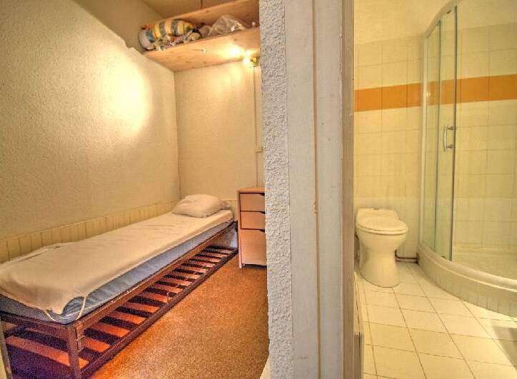 Discover a cozy and functional living space! This property features a compact bedroom with a comfortable bed and a small dresser, perfect for maximizing space.