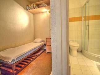 Discover a cozy and functional living space! This property features a compact bedroom with a comfortable bed and a small dresser, perfect for maximizing space.