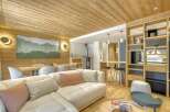 This stunning property boasts a warm and inviting interior, featuring a cozy living room with a plush sectional sofa and decorative pillows.