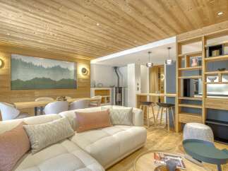 This stunning property boasts a warm and inviting interior, featuring a cozy living room with a plush sectional sofa and decorative pillows.