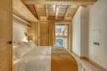 This cozy bedroom features a warm, inviting atmosphere with its wooden ceiling and walls.