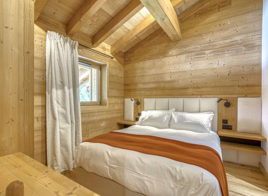 This cozy bedroom features a rustic wooden interior, creating a warm and inviting atmosphere.