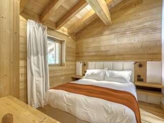 This cozy bedroom features a rustic wooden interior, creating a warm and inviting atmosphere.