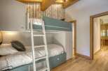 This cozy bedroom features a custom-built bunk bed, perfect for maximizing space.