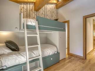 This cozy bedroom features a custom-built bunk bed, perfect for maximizing space.