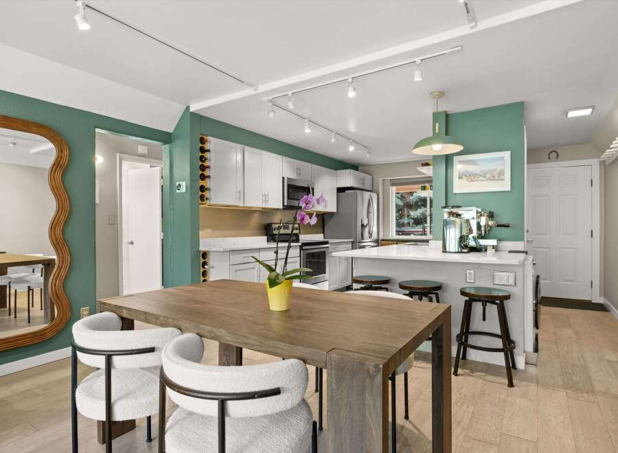 Step into this stunning kitchen, boasting a modern design with sleek white cabinetry and stainless steel appliances.