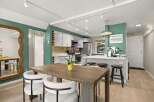 Step into this stunning kitchen, boasting a modern design with sleek white cabinetry and stainless steel appliances.