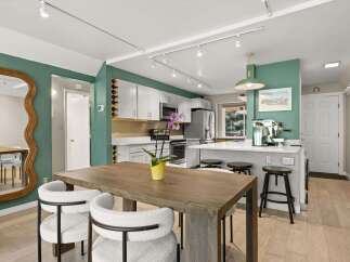 Step into this stunning kitchen, boasting a modern design with sleek white cabinetry and stainless steel appliances.