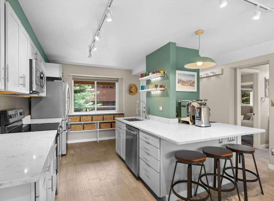This stunning kitchen boasts a modern design with sleek white cabinetry and stainless steel appliances.