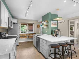 This stunning kitchen boasts a modern design with sleek white cabinetry and stainless steel appliances.