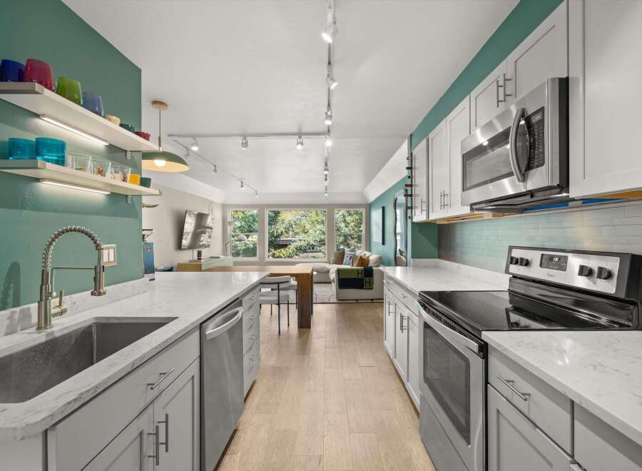 Step into this stunning kitchen, featuring sleek countertops and modern appliances.