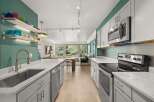 Step into this stunning kitchen, featuring sleek countertops and modern appliances.